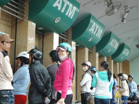 Cho thanh toán qua thẻ Nhiều chủ thẻ chờ rút tiền mặt tại các máy ATM. Ảnh: Hồng Thúy