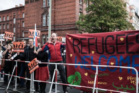 Người ủng hộ dân di cư chăng biểu ngữ chống một đoàn biểu tình phản đối dân di cư ở Munich